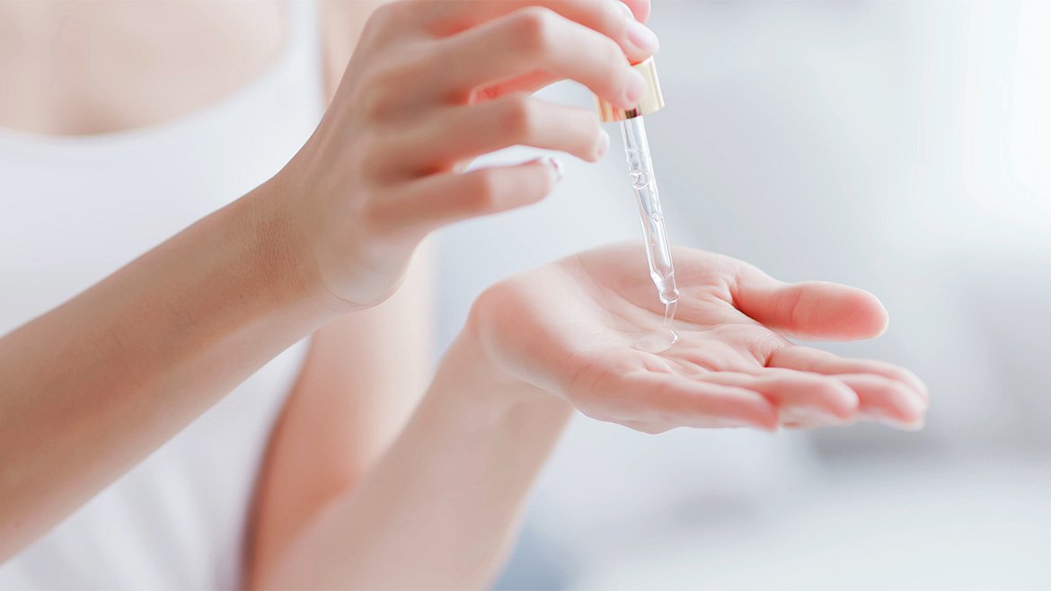 Kobieta trzymająca w rękach pipetę z serum do twarzy